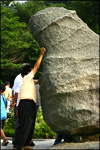 고추공룡 바위를 쓰다듬는 한 할머니. 